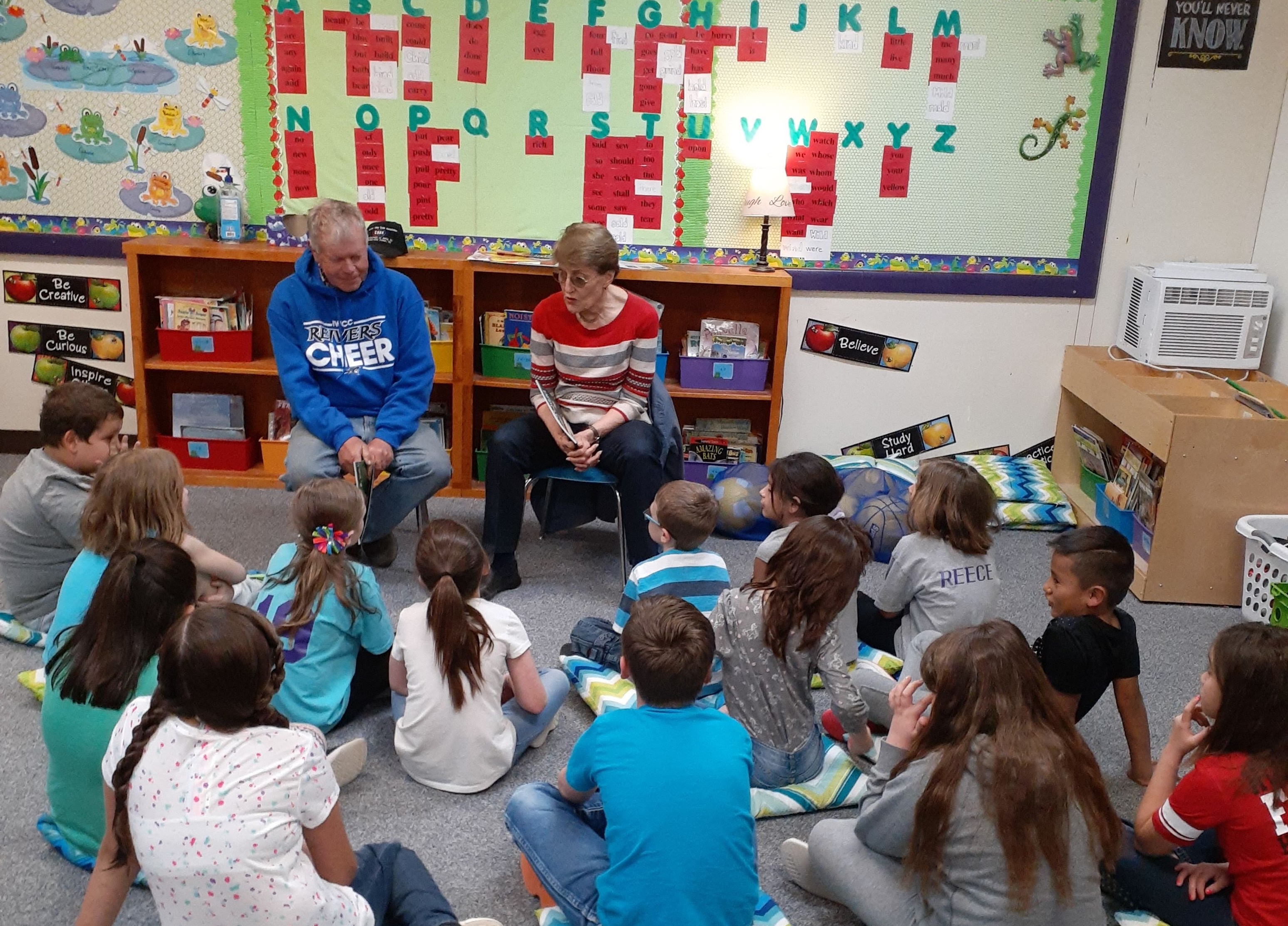 Ross Nielsen is reading to a class as Nancy Aschermann shows the pictures.